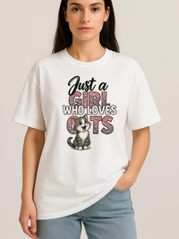 White oversized t-shirt with "Just a Girl Who Loves Cats" text and cute kitten graphic, worn by woman.