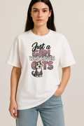 White oversized t-shirt with "Just a Girl Who Loves Cats" text and cute kitten graphic, worn by woman.